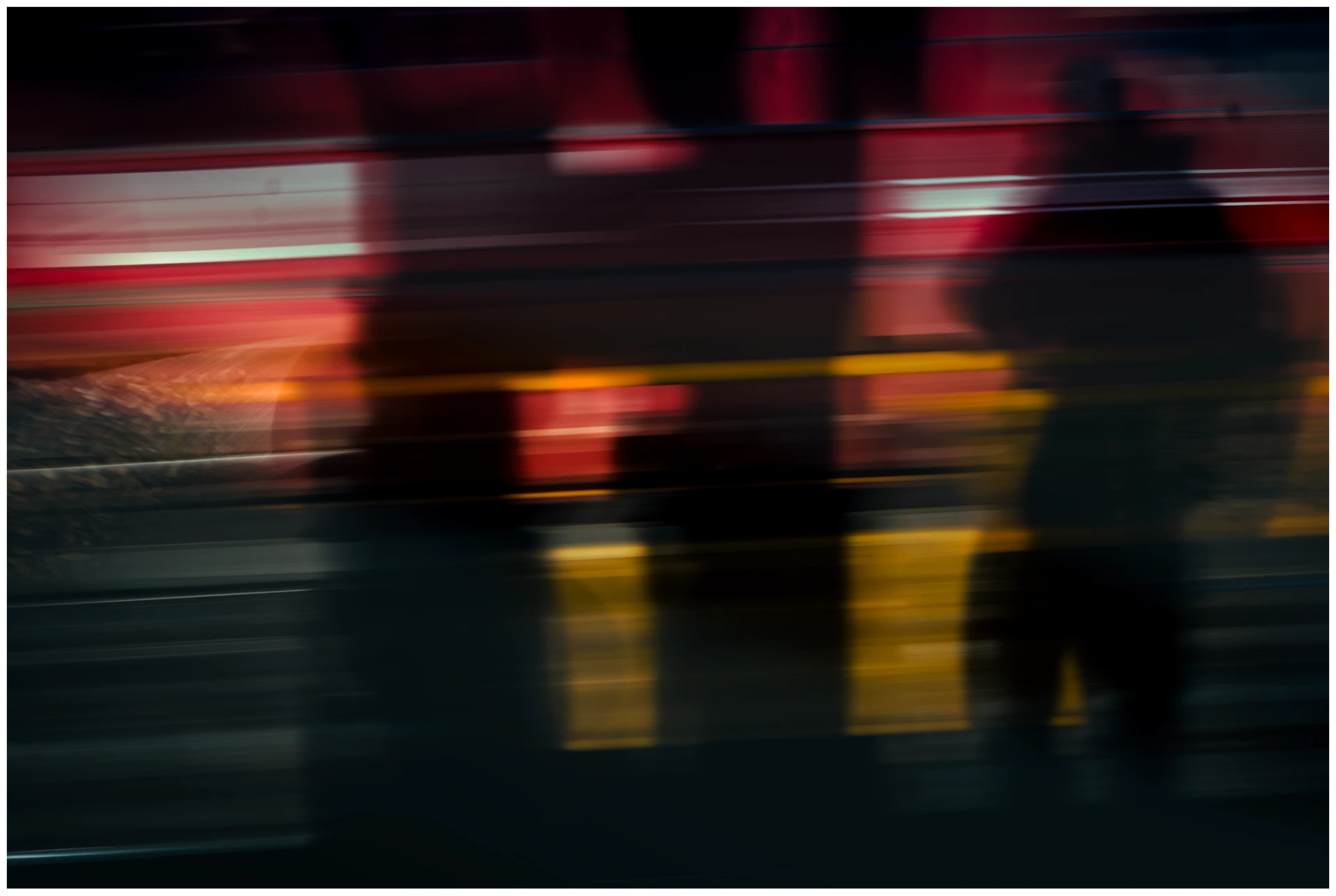 Abstract motion-blurred photograph in red and yellow light with silhouettes